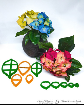 Decupatoare colorate asezate langa Hortensii rosii si albastre, pe un fundal alb