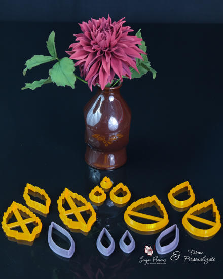 Decupatoare galbene si gri asezate in fata unei Dalii cu petale ascutite