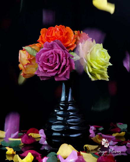 Trandafiri din vafa de diverse culori, asezati in vaza, pe un fundal inchis