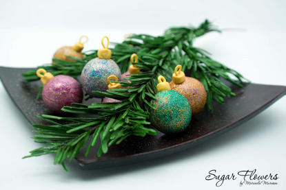 Crenguta de brad comestibila, din pasta de zahar, ornata cu globuri din ciocolata si sclipici comestibil, pe o tavita dreptunghiulara