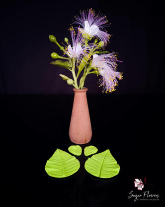 Veinere din silicon asezate langa o floare Barringtonia Asiatica, pe fundal negru